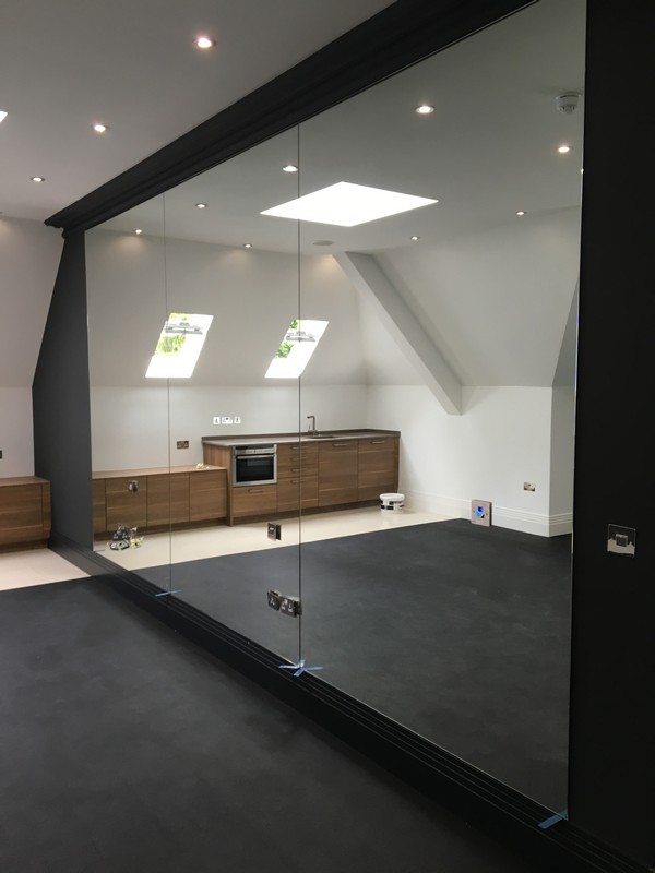 Frameless glass partition in loft conversion by Parson's Green glaziers